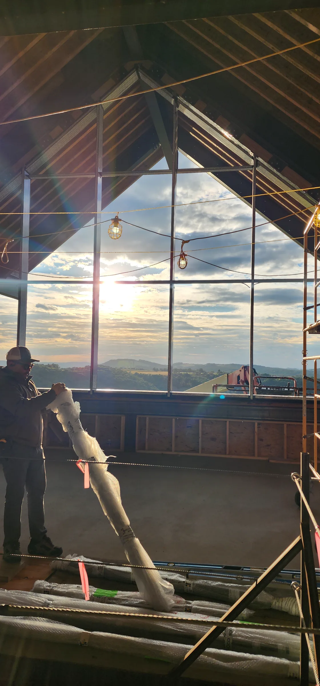 Interior gable framing of the Modern Mountain House silhouetted against the evening valley