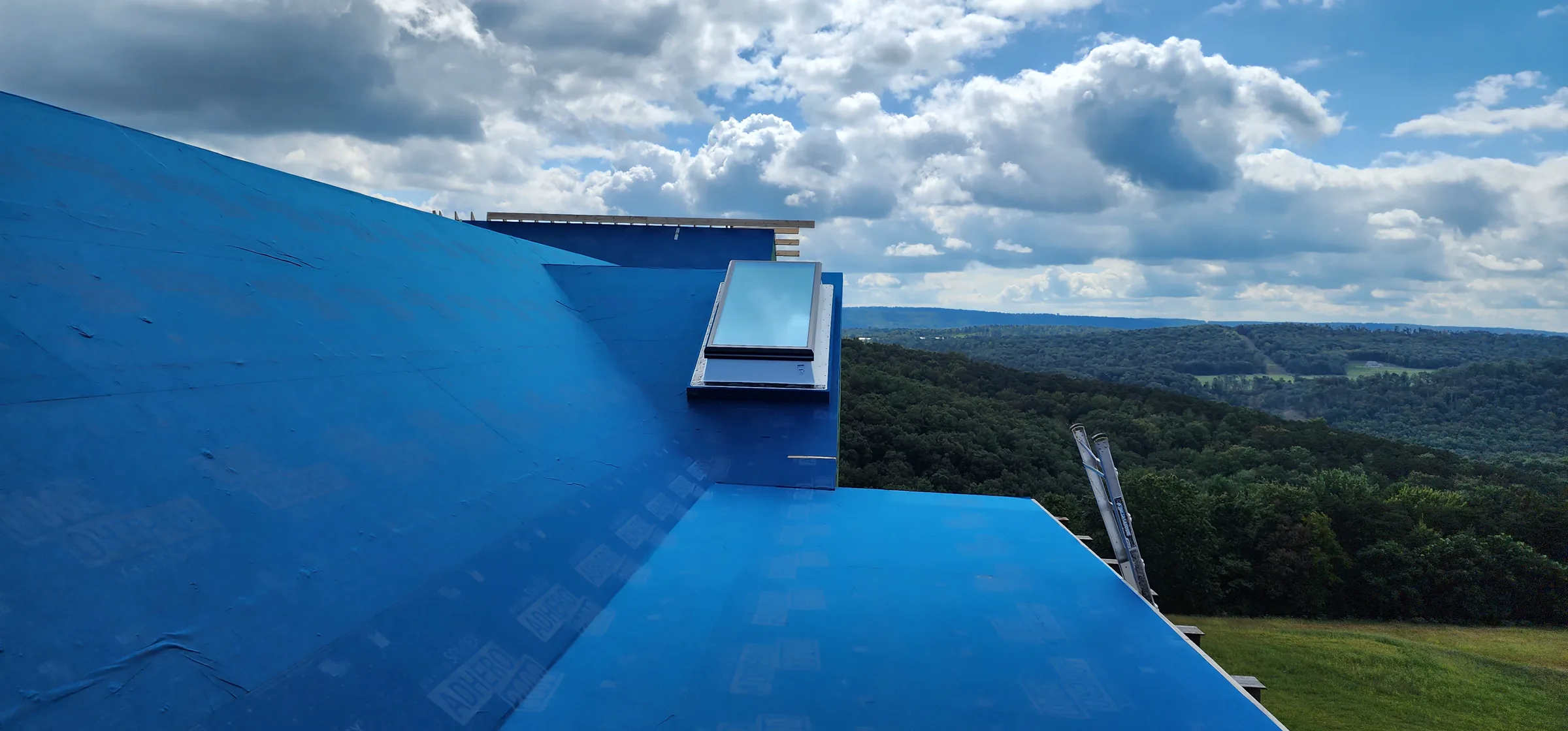 Blue roof membrane across the Modern Mountain House with the valley beyond