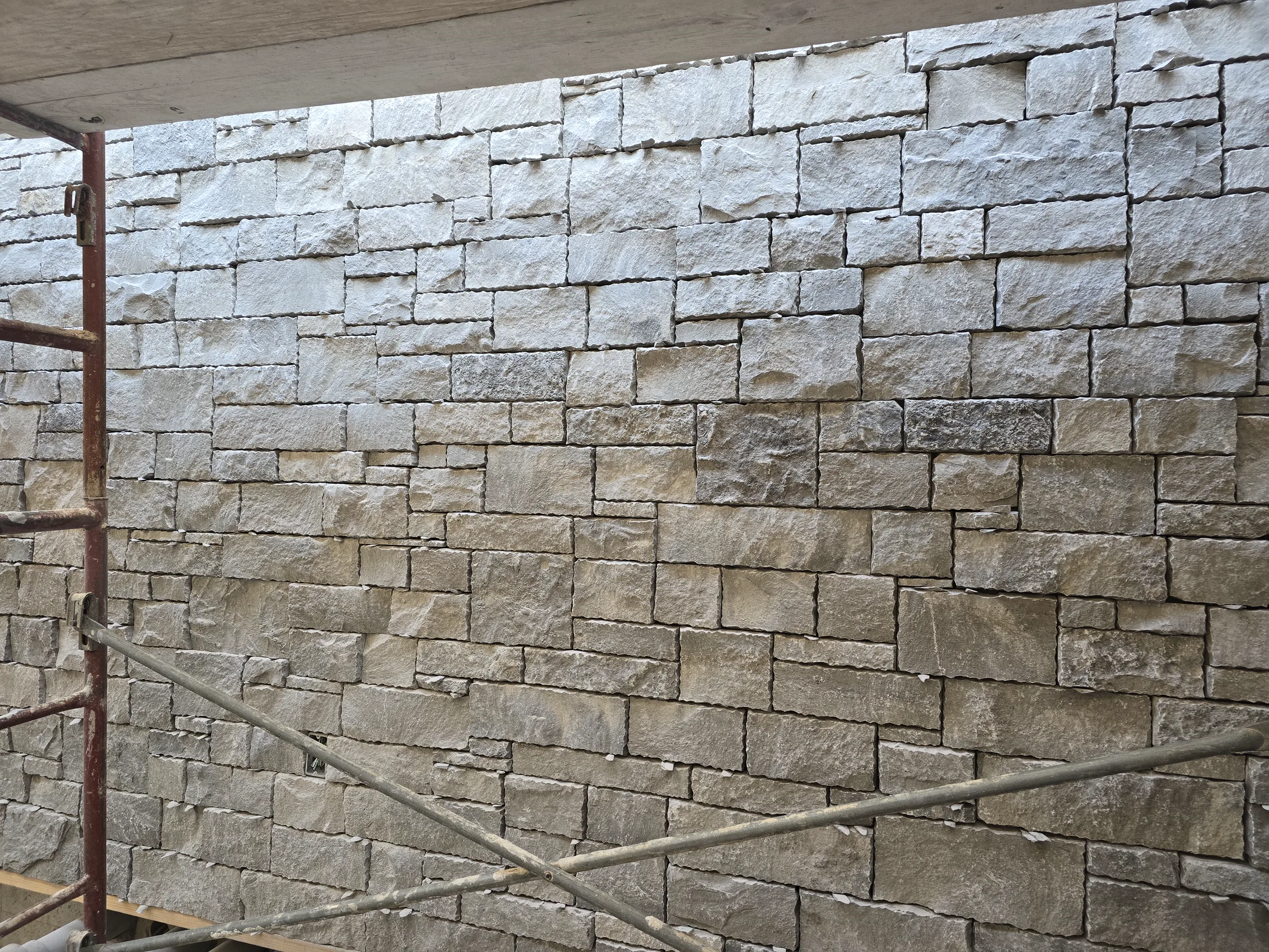 Coursed stone veneer under construction at the Modern Mountain House