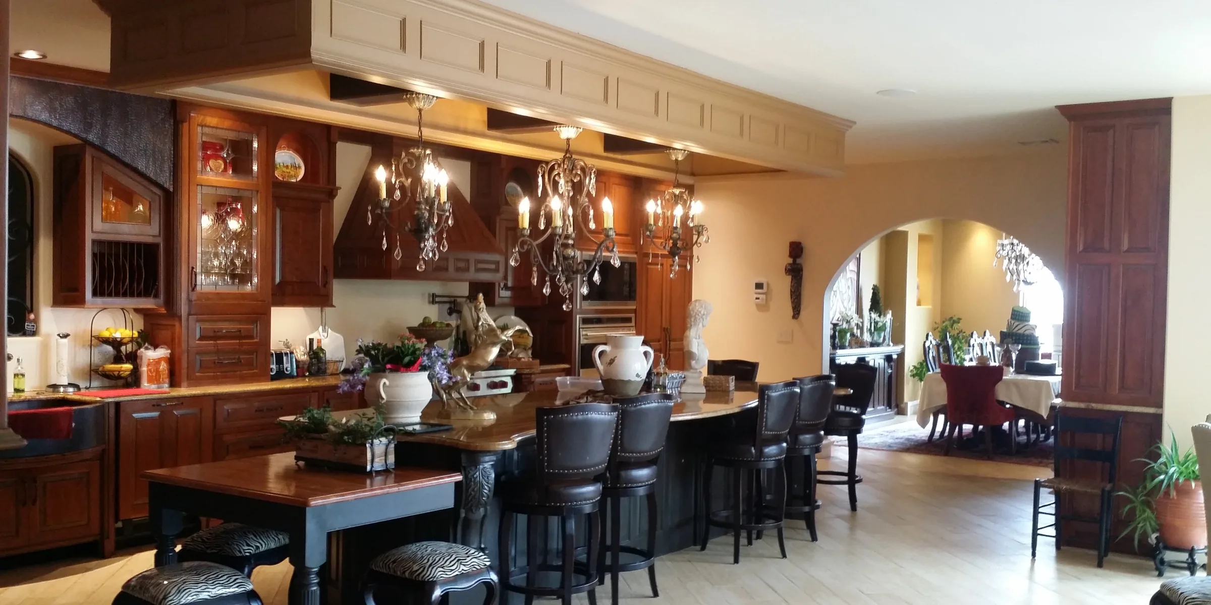 Custom kitchen island and cabinetry opening to a dining area in a completed residence