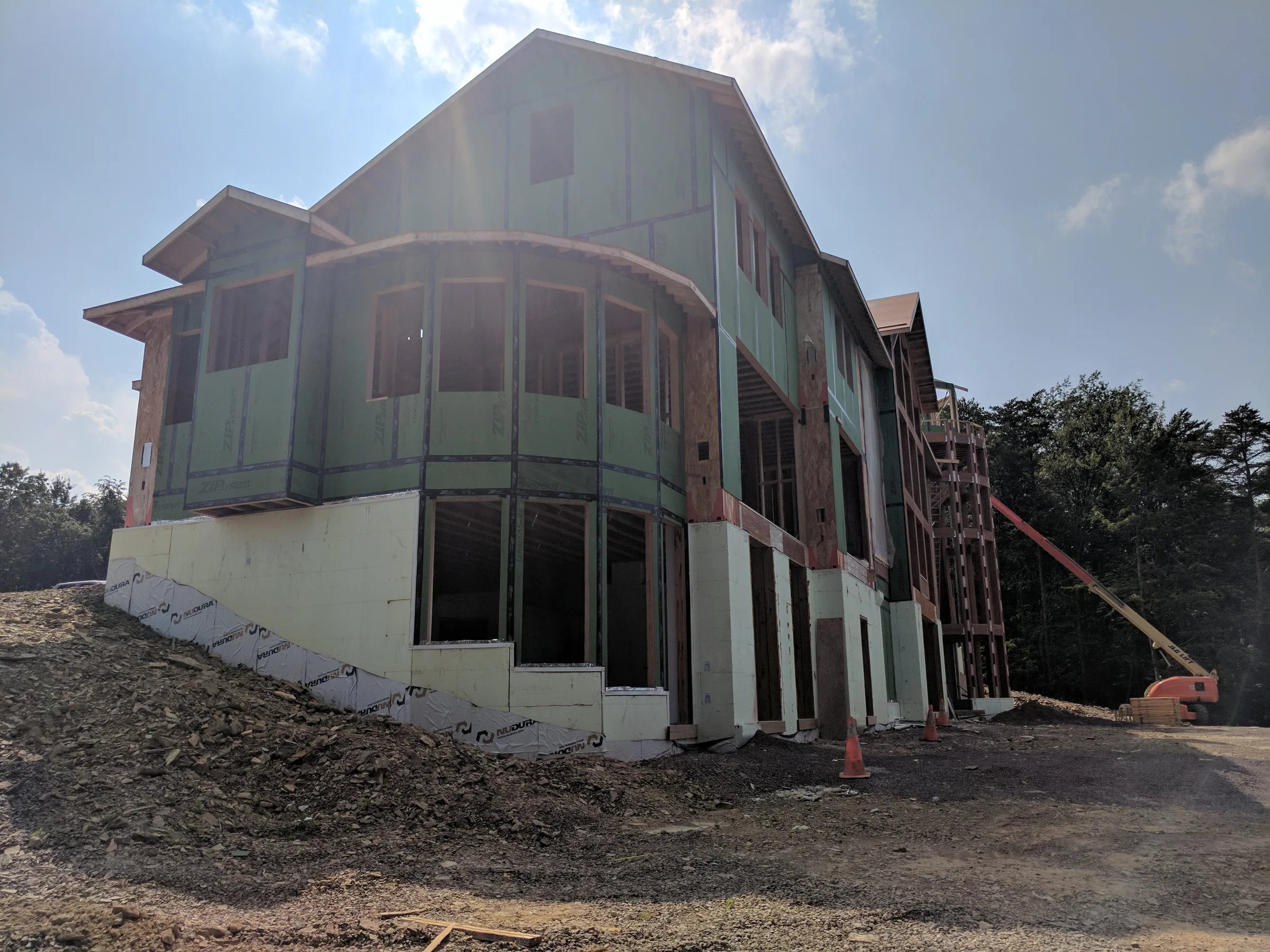 Partially framed hillside residence above insulated concrete foundation walls